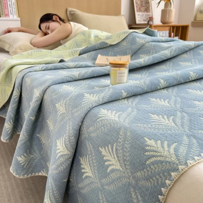 Woman sleeping under a blue patterned blanket in a bedroom setting.