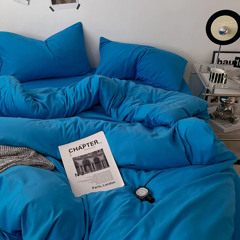 Blue bedding set with a magazine on a bed in a room.