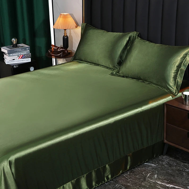 Green satin sheet set on a bed with a lamp and books in the background.
