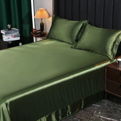 Green satin sheet set on a bed with a lamp and books in the background.