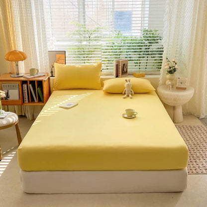 Yellow bedspread on a bed in a bright room with books and decor items.