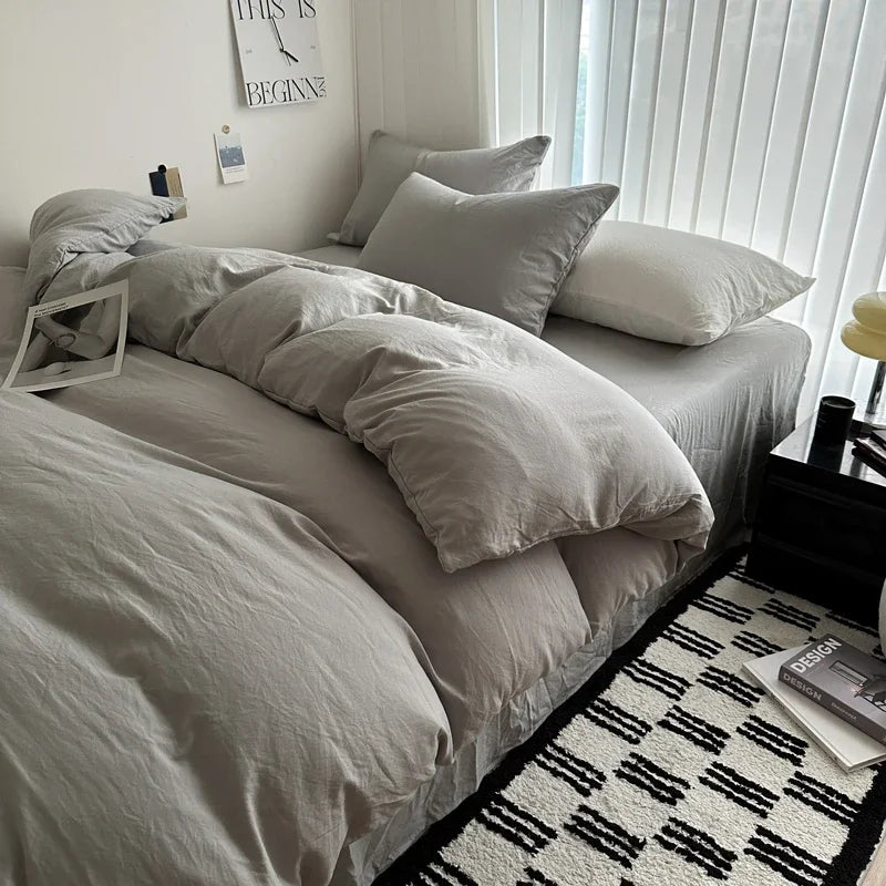 Neatly made bed with light-colored bedding in a bedroom setting.