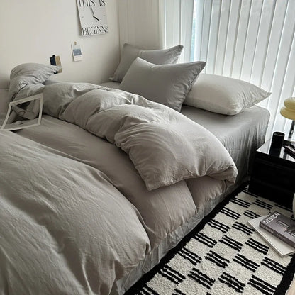 Neatly made bed with light-colored bedding in a bedroom setting.