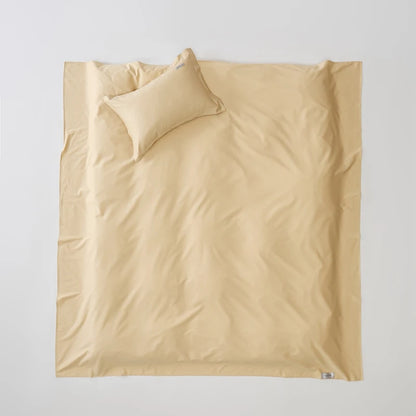 Beige bedding set with a pillow on a light gray background