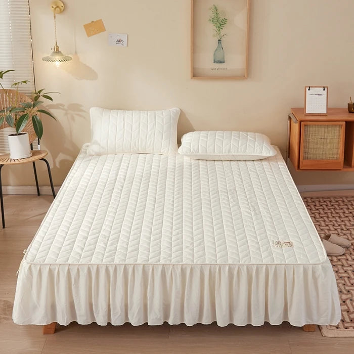 Bed with white quilt and pillows in a bedroom setting