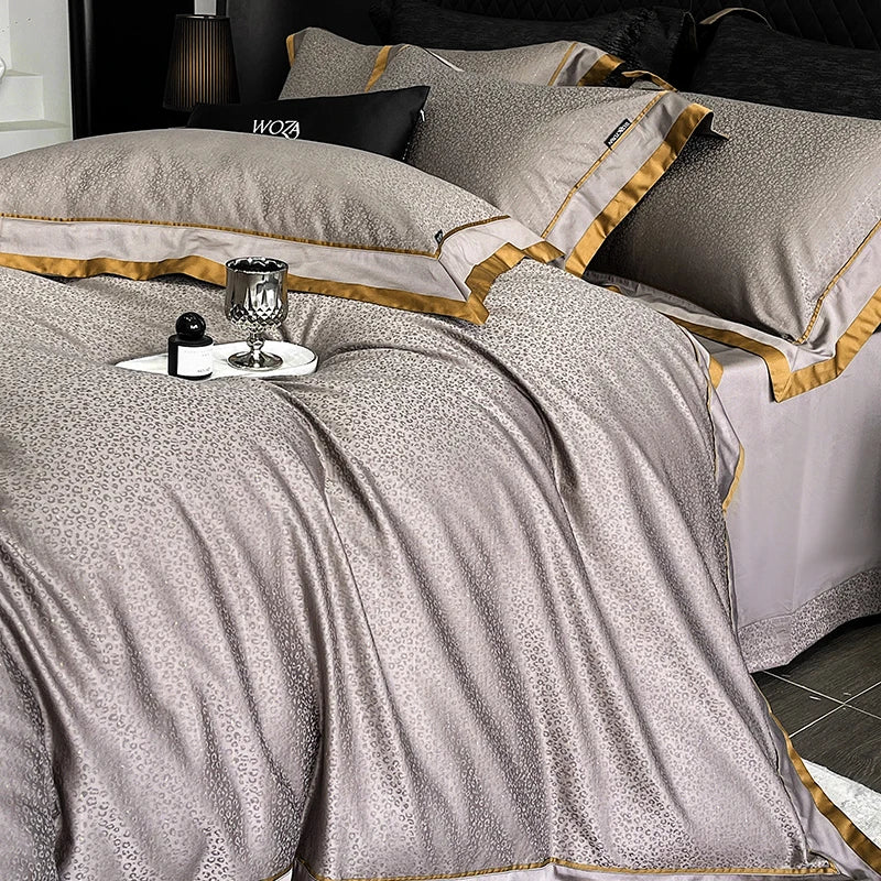 Luxury bed with silver and gold bedding, candles, and decorative items.