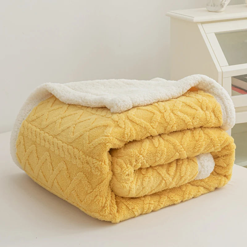Yellow quilted blanket with white trim on a white surface