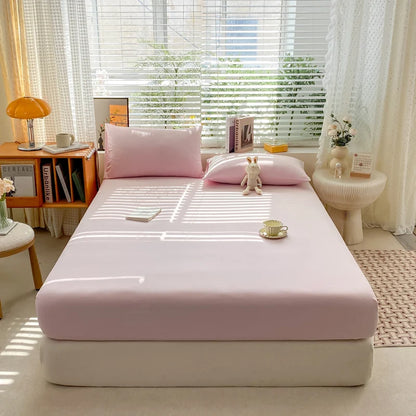 Bed with pink bedding in a bright room with a window and decor.