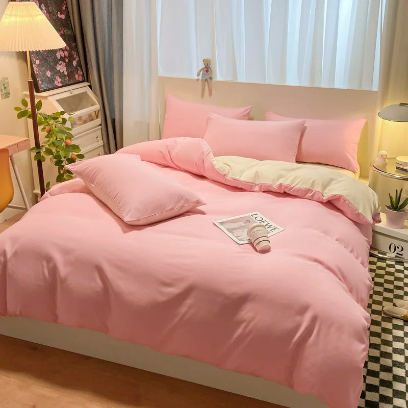 Pink bedding set on a bed in a bedroom with a lamp and plant.