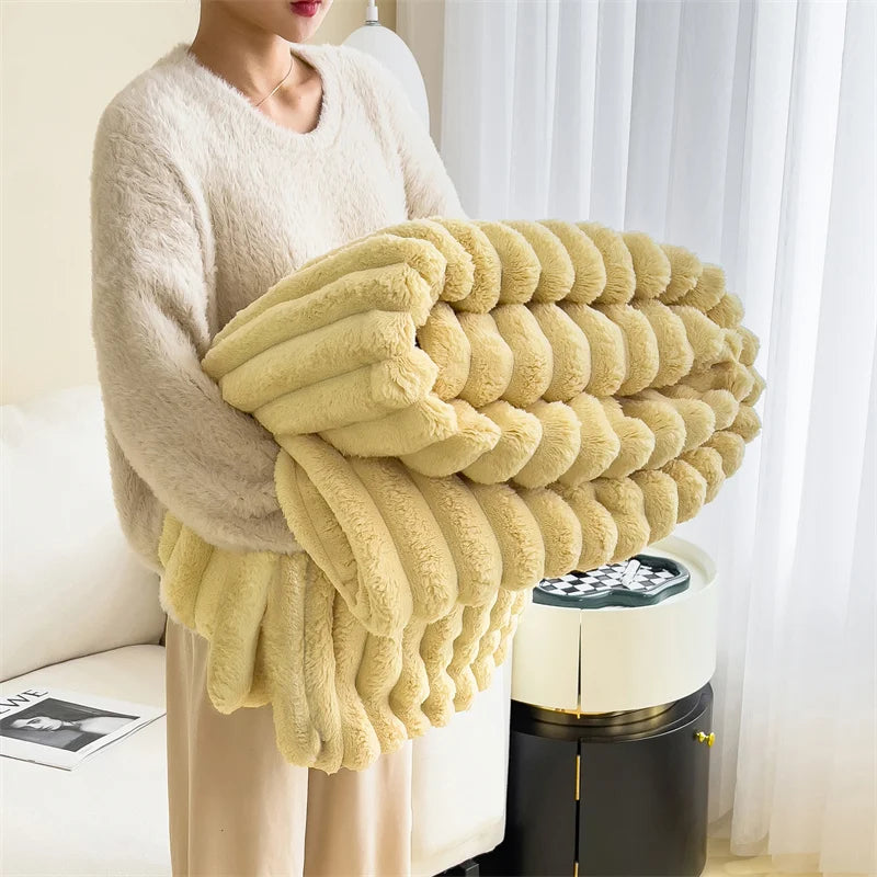 Person holding a large fluffy yellow blanket in a room with a curtain and a small table.