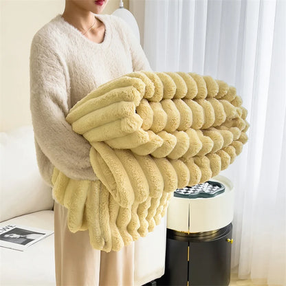 Person holding a large fluffy yellow blanket in a room with a curtain and a small table.