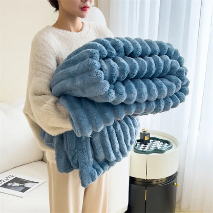 Person holding a large blue fluffy blanket in a living room setting.