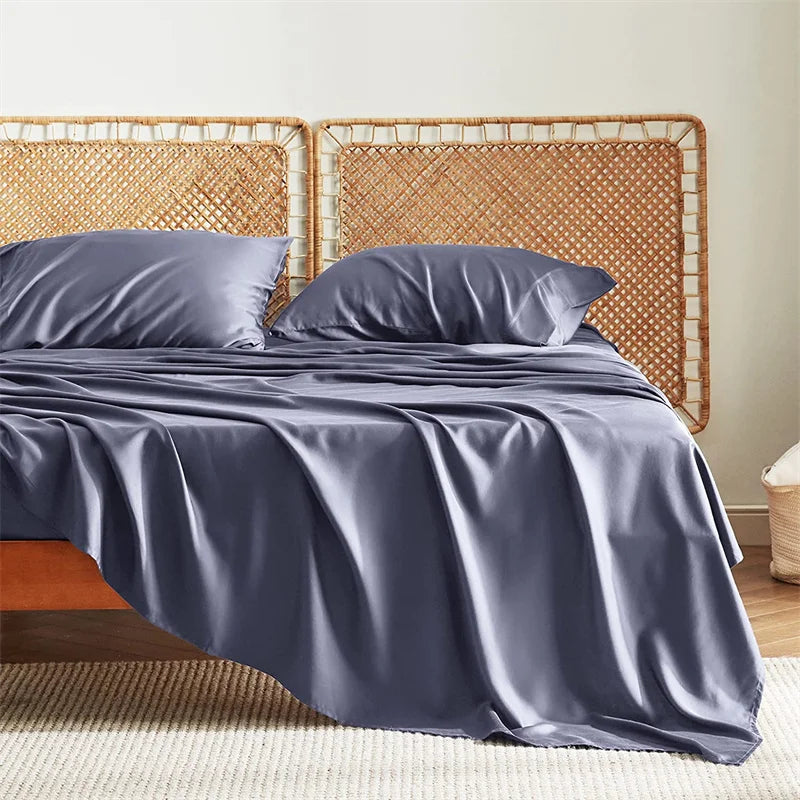 Gray satin sheet set on a bed with a wicker headboard.
