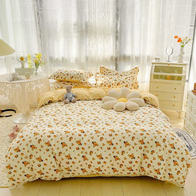 Bedroom with floral bedding and pillows, teddy bear, and decorative items.