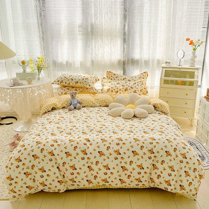 Bedroom with floral bedding and pillows, teddy bear, and decorative items.