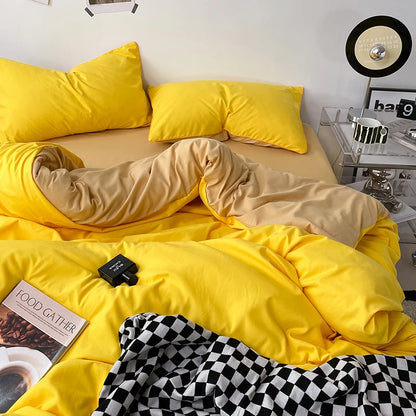 Person lying on a bed with yellow bedding and pillows, next to a nightstand with a lamp.