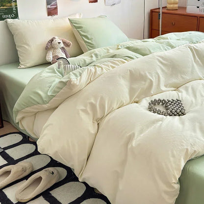 Neatly made bed with light green bedding and a white comforter in a bedroom setting.