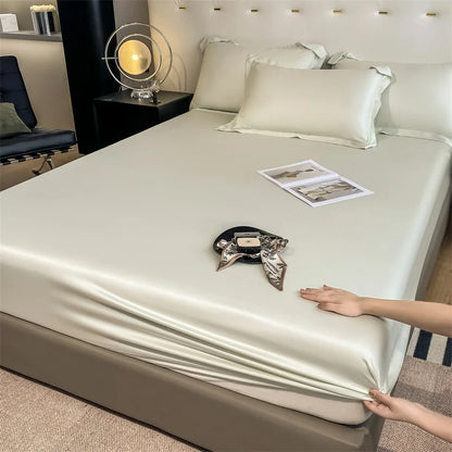 Person adjusting a satin sheet on a bed in a bedroom setting