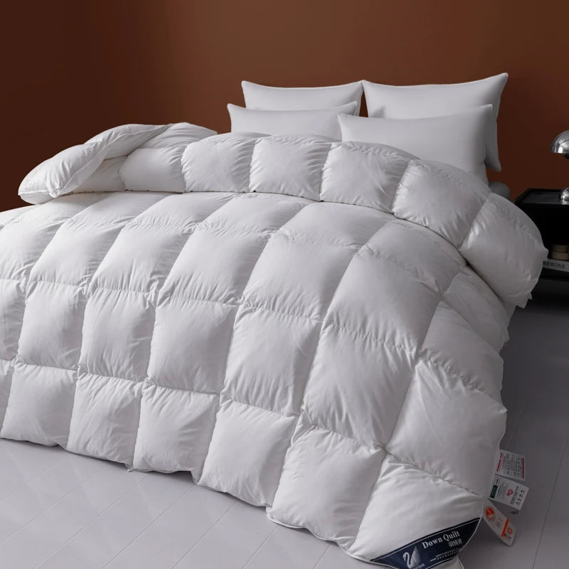 White comforter on a bed with pillows against a brown wall.