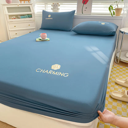 Blue bedsheet set on a bed with pillows and a cup in a bedroom setting.