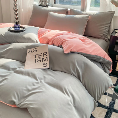 Gray and pink bedding set on a bed with a sign reading 'STERISMS' on a pillow.