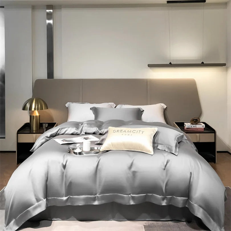 Modern bedroom with gray bedding and decorative pillows, featuring the brand 'Dreamcity'.
