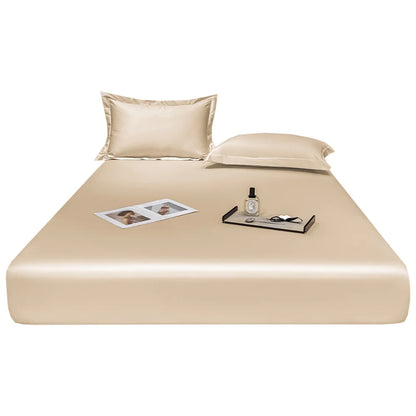 Beige satin sheet set on a bed with a white background