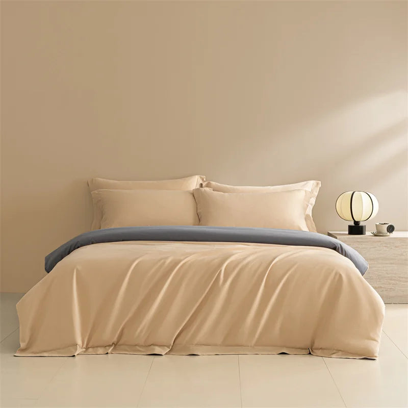 Beige bedding set with gray blanket on a bed in a minimalistic room.