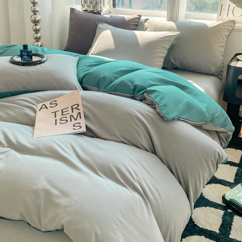 Teal and gray bedding on a bed with a small sign reading 'STERISMS' on a white background.