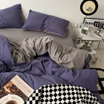 Bedroom with purple bedding and pillows, a nightstand with a lamp, and a record player.