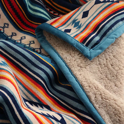 Close-up of a colorful striped blanket with geometric patterns on a textured surface.