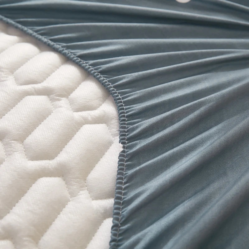 Close-up of a quilted fabric with a visible seam between white and gray sections.
