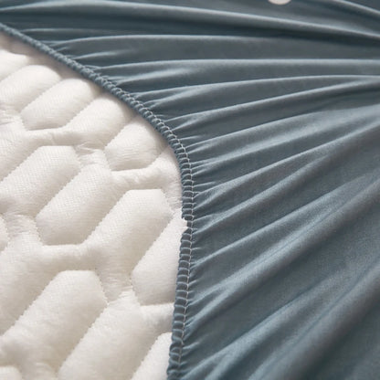 Close-up of a quilted fabric with a visible seam between white and gray sections.