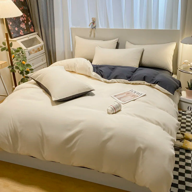 Neatly made bed with white bedding and gray blanket in a bedroom setting.