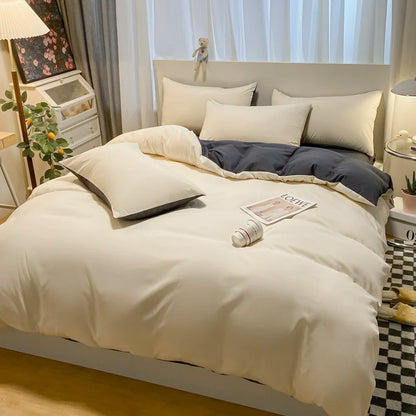 Neatly made bed with white bedding and gray blanket in a bedroom setting.