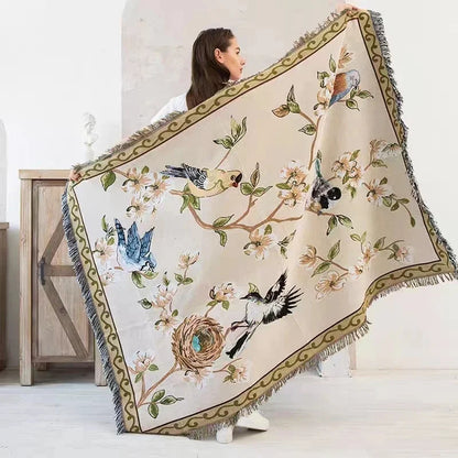 Woman holding a decorative blanket with bird and floral patterns