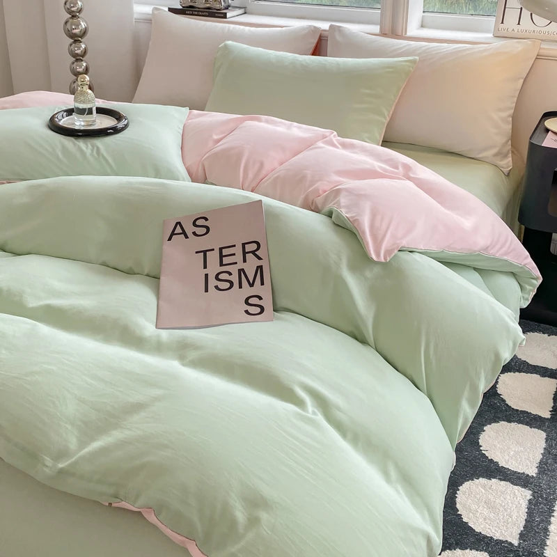 Light green and pink bedding set on a bed with a book titled 'As Ster Isms' on top.