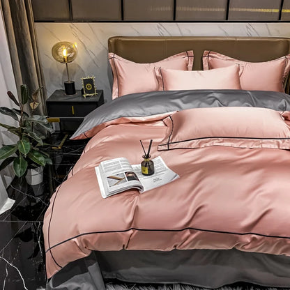 Pink and gray bedding set on a bed in a bedroom with a nightstand and plant.