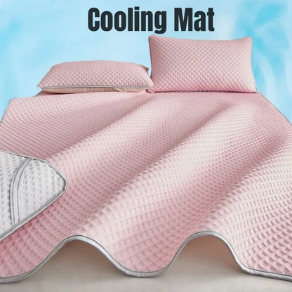 Pink cooling mat with two pillows on a light blue background