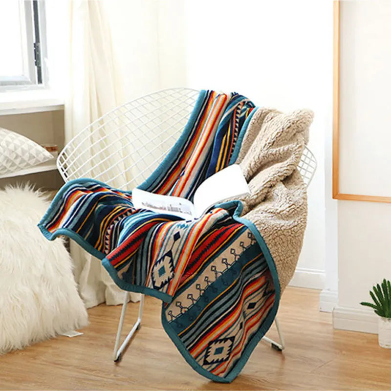 Colorful patterned blanket draped over a chair in a room with light decor