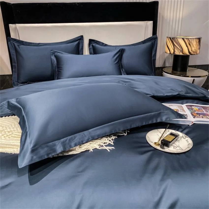 Navy blue bedding set on a bed with a lamp and magazine in the background.