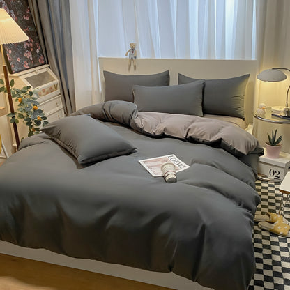 Gray bedding set on a bed in a bedroom with decor elements.
