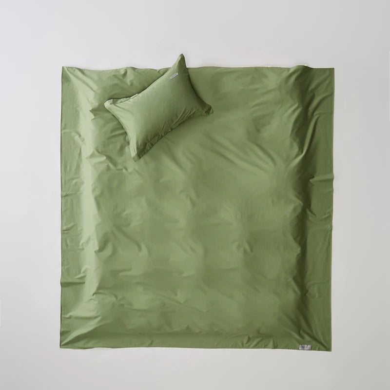 Green bedding set with a pillow on a light gray background