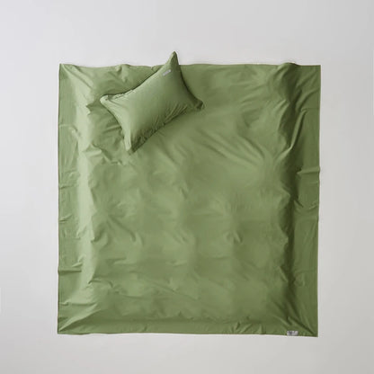Green bedding set with a pillow on a light gray background