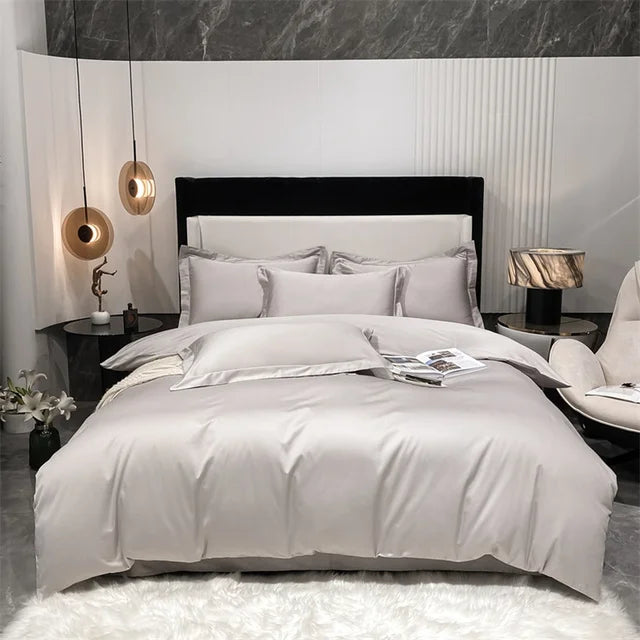 Modern bedroom with a bed featuring white bedding and gray pillows, nightstands with lamps, and decorative elements.