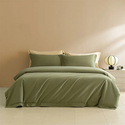 Green bedspread set on a bed in a room with a beige wall and nightstand.