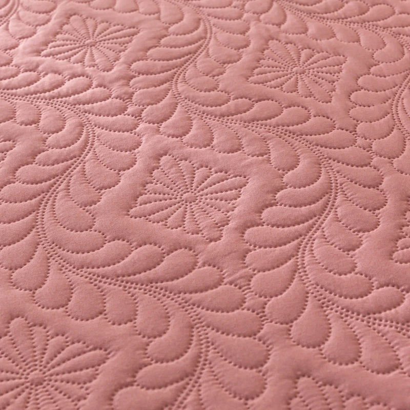 Close-up of pink quilted fabric with a floral pattern