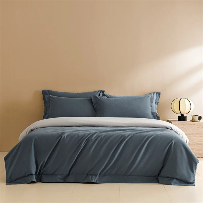 Blue bedding set on a bed against a beige wall with a lamp in the corner.