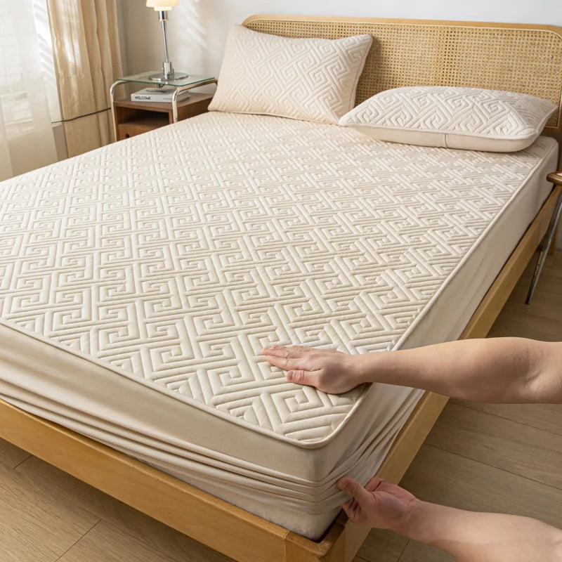 Person adjusting a mattress cover on a bed in a bedroom setting