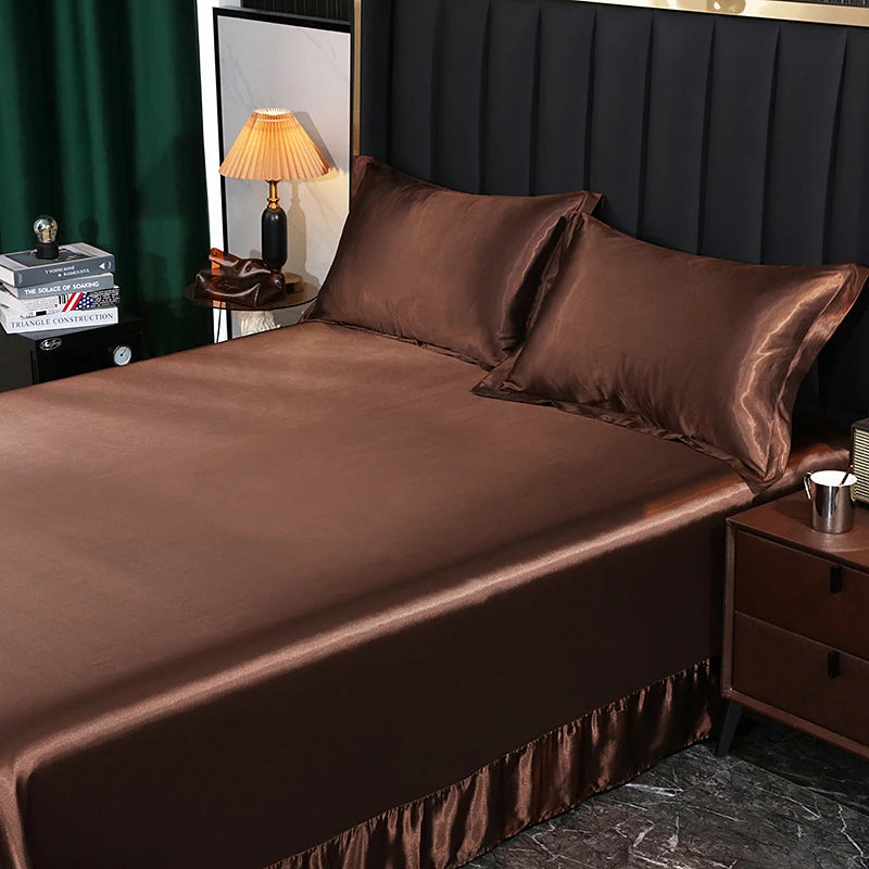 Brown satin bed sheets on a bed with matching pillows, in a bedroom setting.